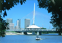 Decorative bridge over a river. There is a circlular structure in the middle of the bridge, with a tall column protruding from the middle. Multiple cables fan out from the column to support it.